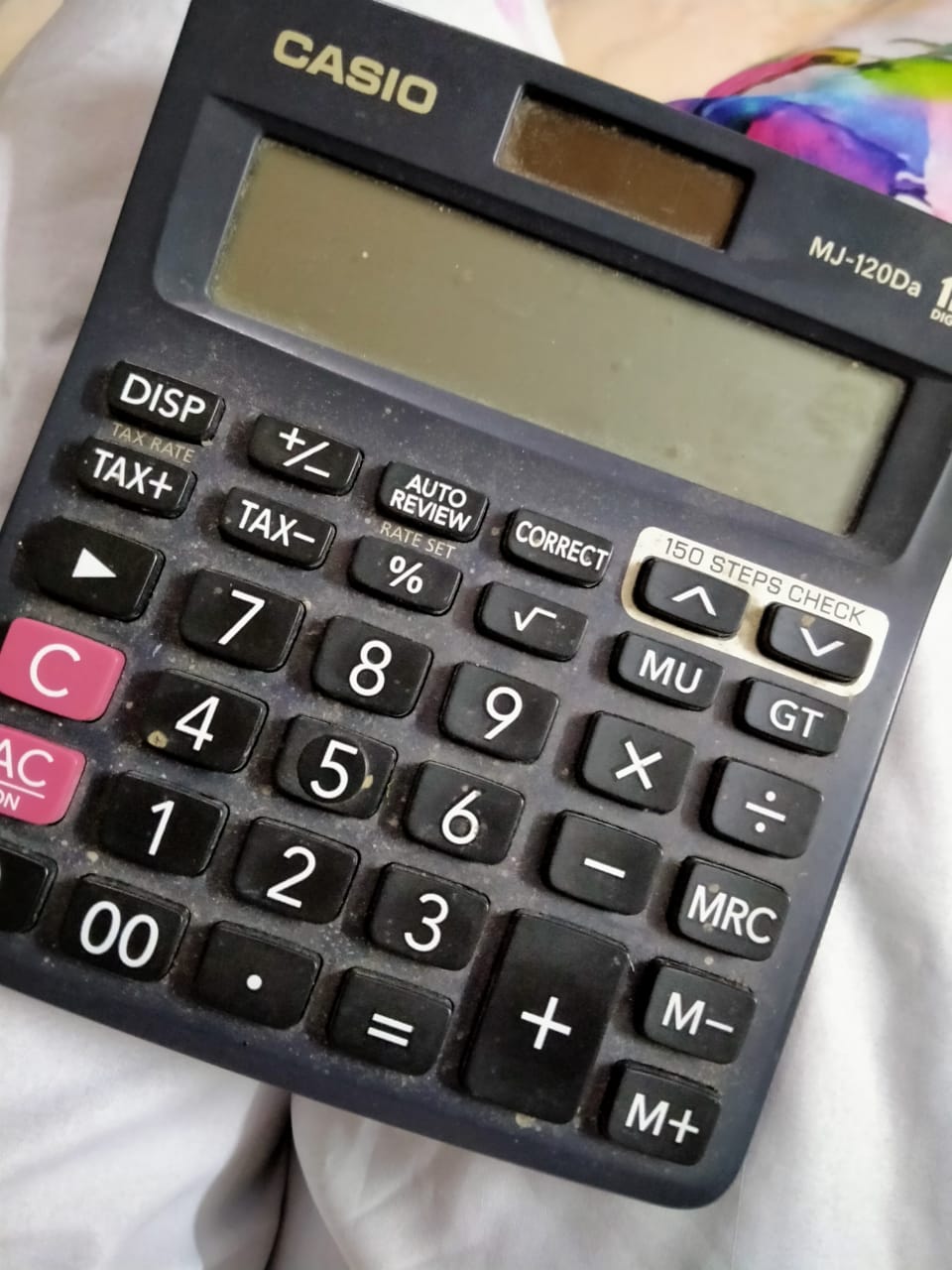 Close-up of a black Casio desktop calculator with a solar panel, display and arithmetic keys.