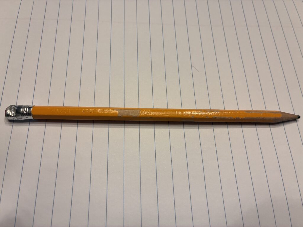 A pencil resting on a notebook.